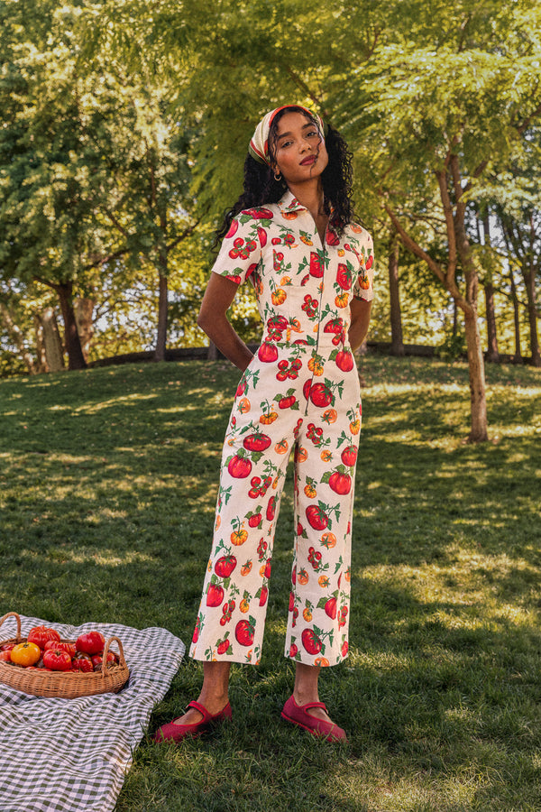 Woman in mango print jumpsuit at market.