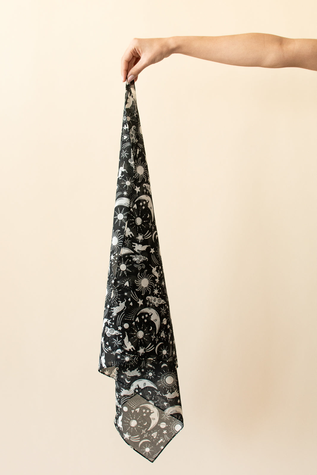 Black patterned scarf held by a hand