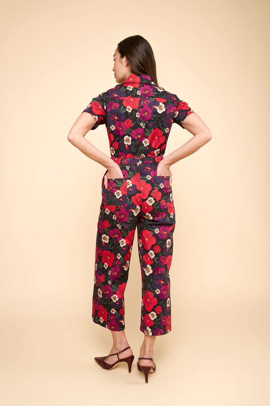 Back view of Quincy jumpsuit in pansy. Red and blue floral pattern